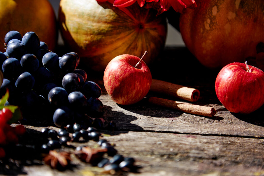 pumpkin, grapes, apples, viburnum, currants, and cinnamon sticks with high-angle shadows
