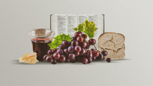 Open Bible with communion cup, grapes, and broken bread in front of it
